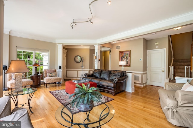 41 Musket Ct, West Chester, PA 19382 - living room with decorative columns, ornamental molding, stairs, light wood-style floors, and a wainscoted wall