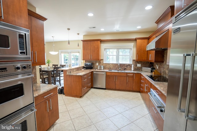 5280 Ten Oaks Rd, Clarksville, MD 21029 - kitchen with built in appliances, decorative backsplash, brown cabinets, a peninsula, and healthy amount of natural light