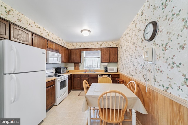 15111 Ina Dr, Philadelphia, PA 19116 - kitchen featuring white appliances, wallpapered walls, a wainscoted wall, a sink, and light countertops
