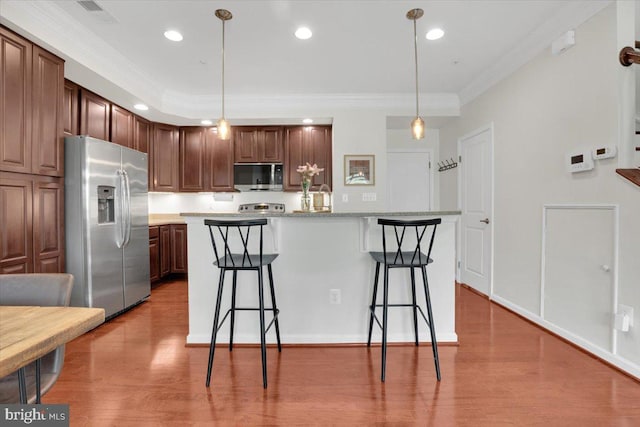 21668 Pattyjean Ter Unit 0, Ashburn, VA 20147 - kitchen featuring appliances with stainless steel finishes, a breakfast bar, crown molding, wood finished floors, and decorative light fixtures