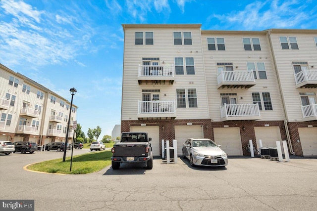 21668 Pattyjean Ter Unit 0, Ashburn, VA 20147 - view of building exterior featuring a garage, driveway, and central air condition unit