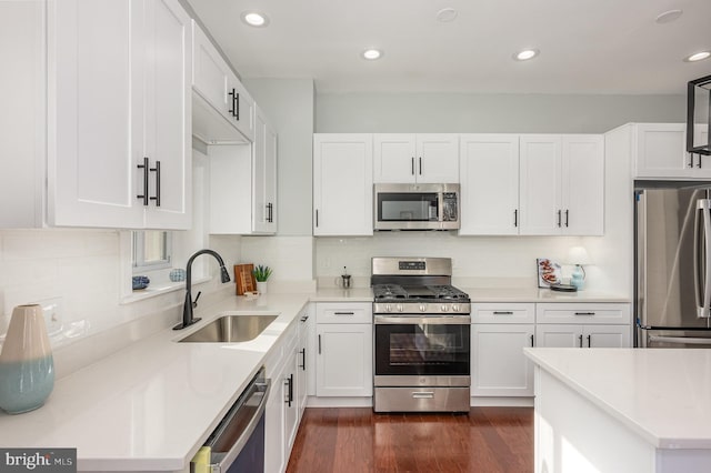 2621 E Monument St, Baltimore, MD 21205 - kitchen featuring stainless steel appliances, a sink, white cabinets, light countertops, and dark wood-type flooring