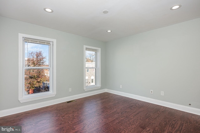 2621 E Monument St, Baltimore, MD 21205 - empty room featuring dark wood-type flooring, healthy amount of natural light, recessed lighting, and baseboards