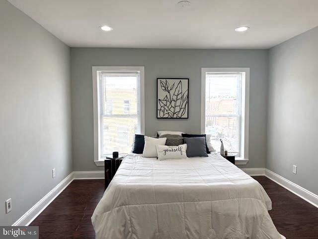 2621 E Monument St, Baltimore, MD 21205 - bedroom featuring multiple windows, baseboards, dark wood-type flooring, and recessed lighting