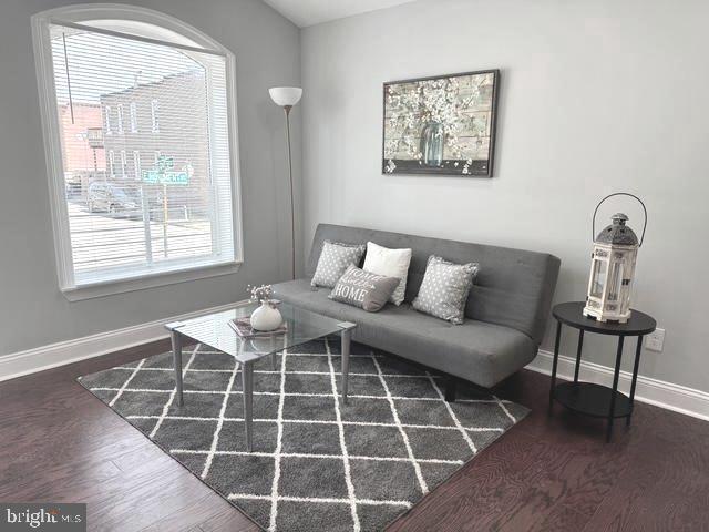 2621 E Monument St, Baltimore, MD 21205 - living area with wood finished floors and baseboards