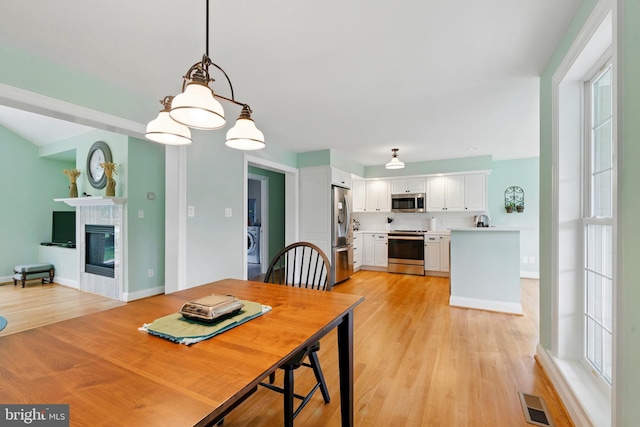 201 Pondview Ct, Chestertown, MD 21620 - dining room with light wood-style floors, a tiled fireplace, and baseboards