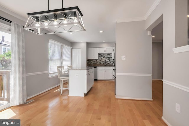 308 Curry Ford Ln, Gaithersburg, MD 20878 - kitchen with healthy amount of natural light, white cabinetry, decorative backsplash, light wood finished floors, and crown molding