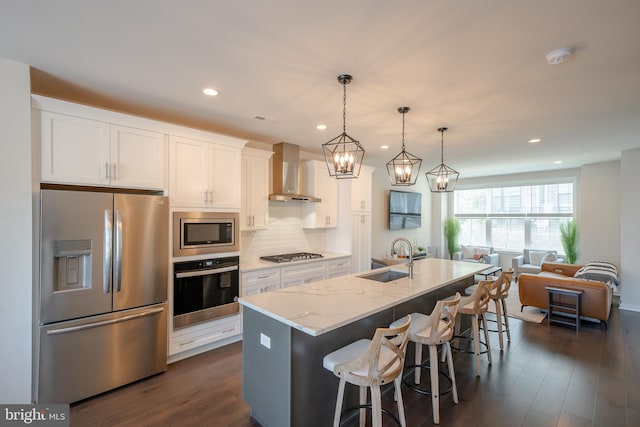 301 Star Tavern Ln, West Chester, PA 19382 - kitchen with stainless steel appliances, wall chimney range hood, a sink, white cabinets, and recessed lighting