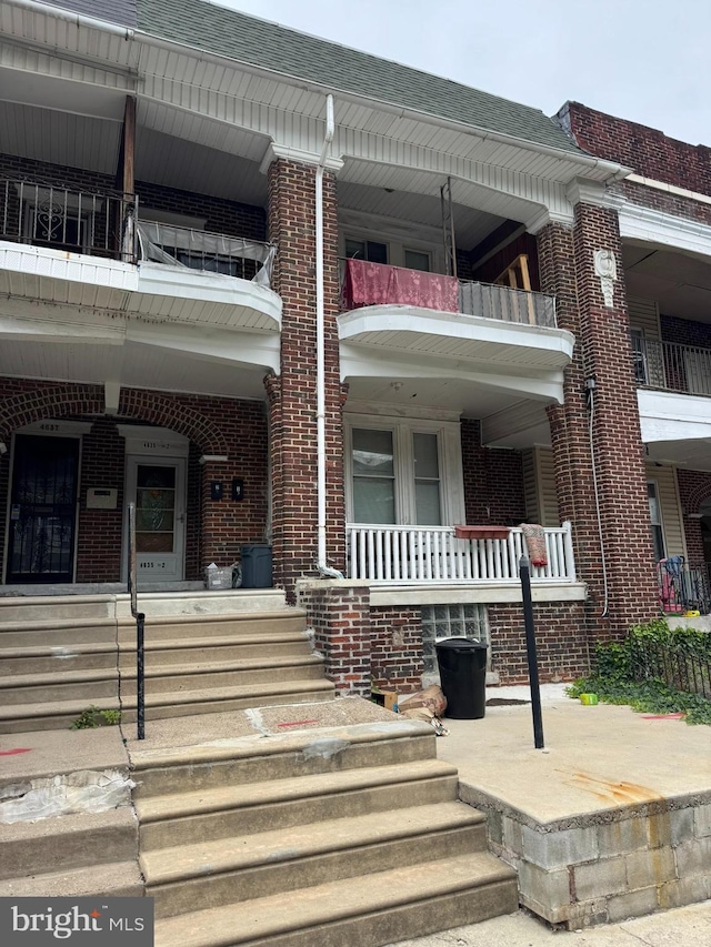 4635 Sansom St, Philadelphia, PA 19139 - doorway to property featuring brick siding, a porch, and a balcony
