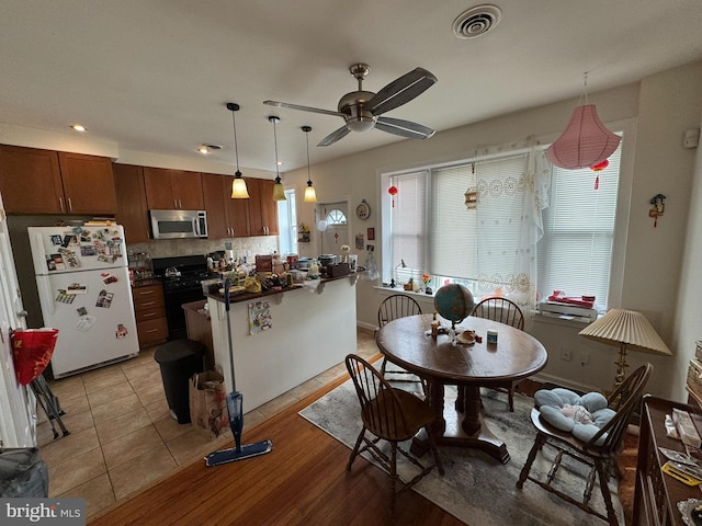 4635 Sansom St, Philadelphia, PA 19139 - kitchen featuring freestanding refrigerator, stainless steel microwave, black gas range oven, healthy amount of natural light, and recessed lighting