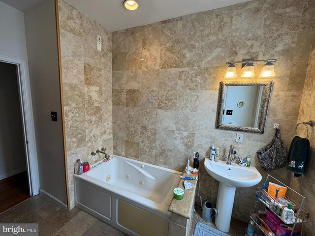 4635 Sansom St, Philadelphia, PA 19139 - bathroom featuring tile walls, a jetted tub, and baseboards