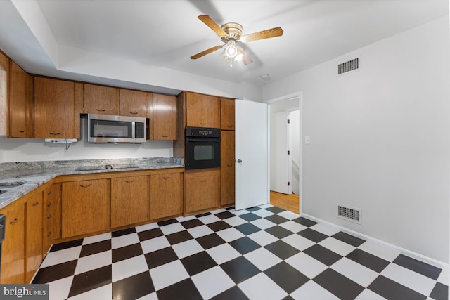 4503 Poppe Pl, Temple Hills, MD 20748 - kitchen with black appliances, tile patterned floors, a ceiling fan, and brown cabinetry