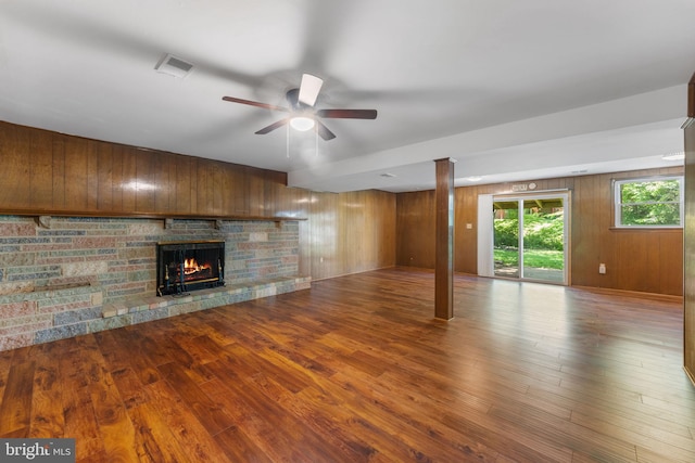 4503 Poppe Pl, Temple Hills, MD 20748 - unfurnished living room featuring a fireplace, ceiling fan, dark wood-style floors, and wooden walls