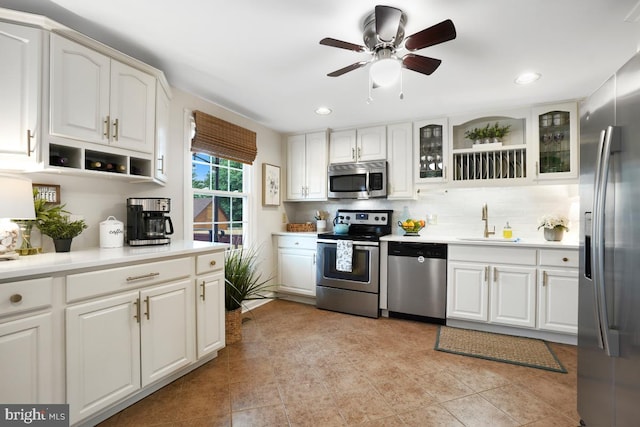 8588 King Carter St, Manassas, VA 20110 - kitchen featuring stainless steel appliances, a sink, backsplash, white cabinetry, and glass insert cabinets