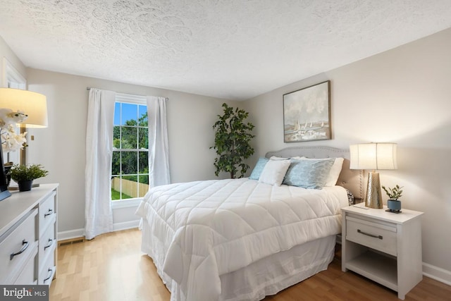 8588 King Carter St, Manassas, VA 20110 - bedroom with light wood-style flooring, a textured ceiling, and baseboards
