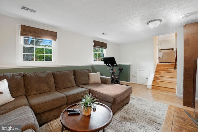 8588 King Carter St, Manassas, VA 20110 - living room with light wood-style floors, stairway, and a textured ceiling