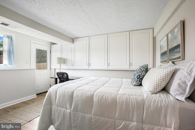 8588 King Carter St, Manassas, VA 20110 - bedroom featuring wood finished floors, a textured ceiling, and baseboards