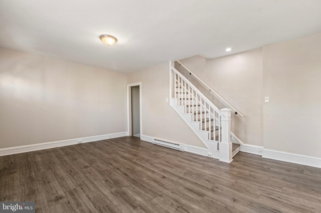 100 Chester Pike, Darby, PA 19023 - unfurnished living room with a baseboard heating unit, wood finished floors, stairway, and baseboards