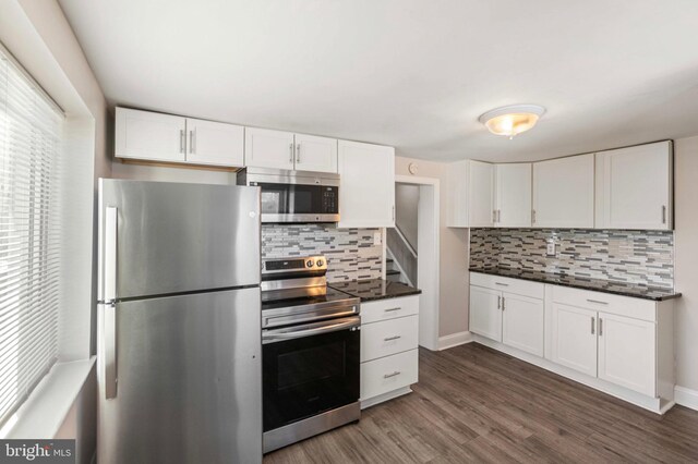 100 Chester Pike, Darby, PA 19023 - kitchen featuring appliances with stainless steel finishes, dark countertops, decorative backsplash, and white cabinetry