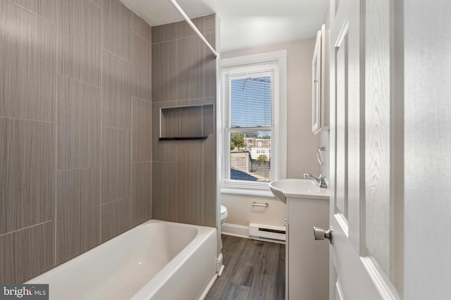100 Chester Pike, Darby, PA 19023 - bathroom featuring a baseboard heating unit, toilet, vanity, wood finished floors, and bathing tub / shower combination