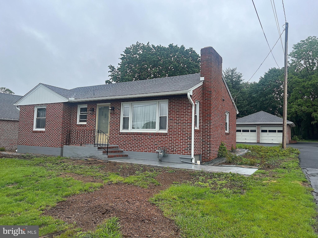 622 S Allison St, Greencastle, PA 17225 - view of front of home featuring brick siding, a chimney, a garage, an outbuilding, and roof with shingles
