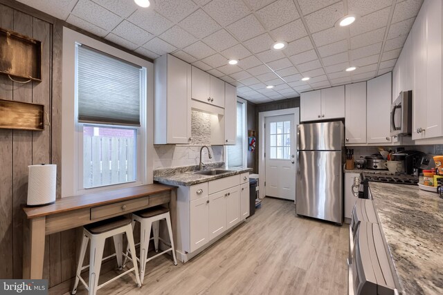 114 Walnut St, Columbia, PA 17512 - kitchen featuring appliances with stainless steel finishes, a sink, decorative backsplash, white cabinets, and light wood-type flooring