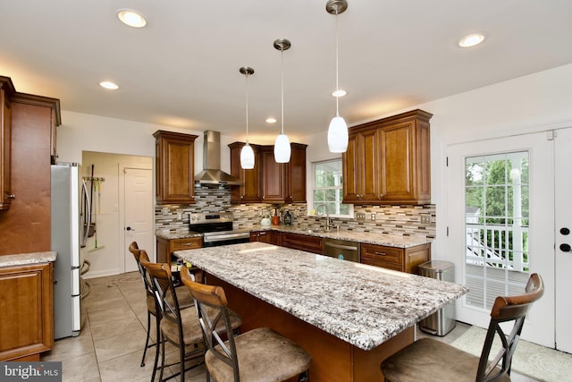 8919 Kiger St, Lorton, VA 22079 - kitchen with wall chimney range hood, stainless steel appliances, plenty of natural light, a breakfast bar area, and recessed lighting