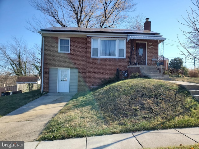 4905 66th Ave, Hyattsville, MD 20784 - view of front facade with a chimney, brick siding, solar panels, and a front lawn