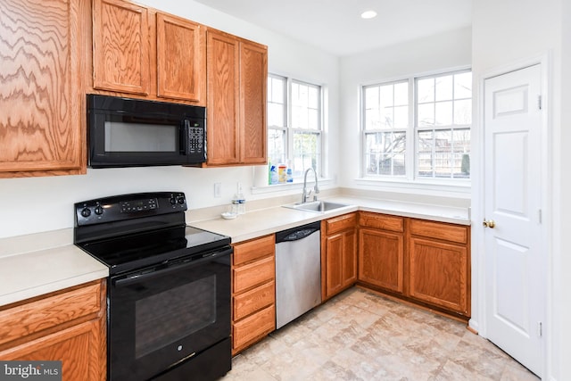 3313 Cornwell Dr SE, Washington, DC 20032 - kitchen with black appliances, a sink, light countertops, and brown cabinetry