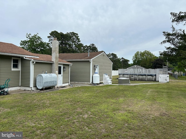 117 W Waverly St S, Browns Mills, NJ 8015 - back of property with oil tank, a yard, a wooden deck, and a chimney
