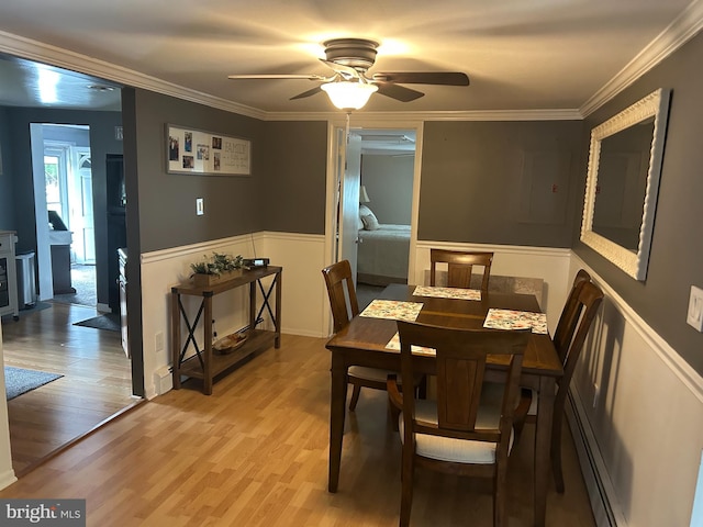 117 W Waverly St S, Browns Mills, NJ 8015 - dining area with light wood-style floors, ceiling fan, crown molding, a wainscoted wall, and a baseboard heating unit