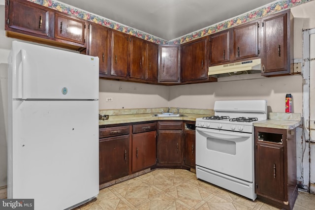 2531 N Lawrence St, Philadelphia, PA 19133 - kitchen with white appliances, under cabinet range hood, light countertops, a sink, and light flooring