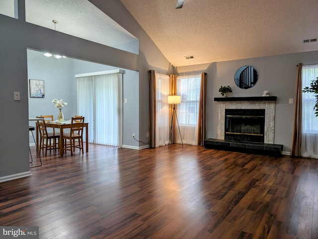407 Talon Ct, Lawrence, NJ 08648 - living area with a textured ceiling, wood finished floors, a tile fireplace, vaulted ceiling, and baseboards