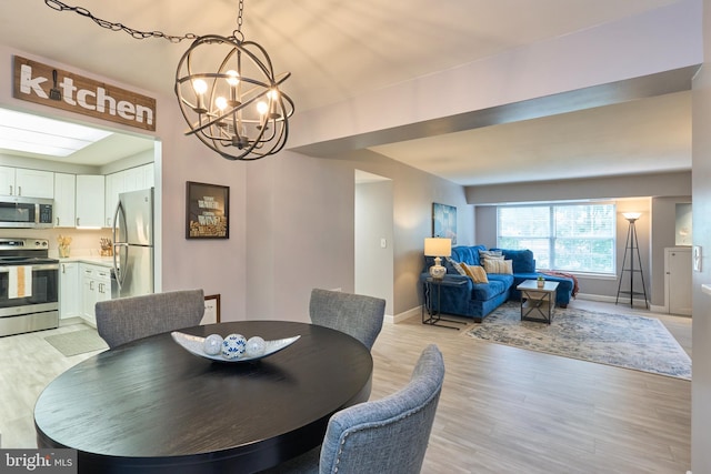 7621 Tremayne Pl Unit 205, Mclean, VA 22102 - dining area with a chandelier, light wood-style flooring, and baseboards