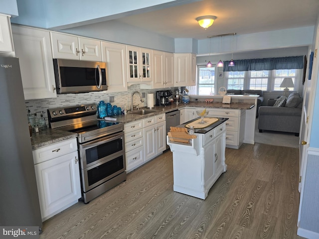 817 Lafayette Blvd, Brigantine, NJ 08203 - kitchen with stainless steel appliances, a sink, a peninsula, wood finished floors, and white cabinetry