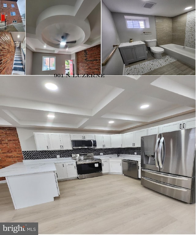 901 N Luzerne Ave, Baltimore, MD 21205 - kitchen featuring stainless steel appliances, light countertops, white cabinets, decorative backsplash, and light wood-style flooring
