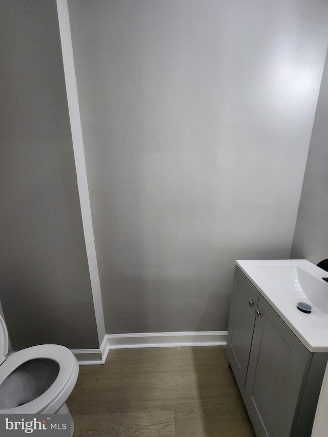 901 N Luzerne Ave, Baltimore, MD 21205 - half bathroom featuring toilet, baseboards, wood finished floors, and vanity