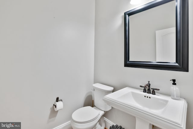 16328 Limestone Ct, Leesburg, VA 20176 - half bathroom featuring toilet, baseboards, and a sink