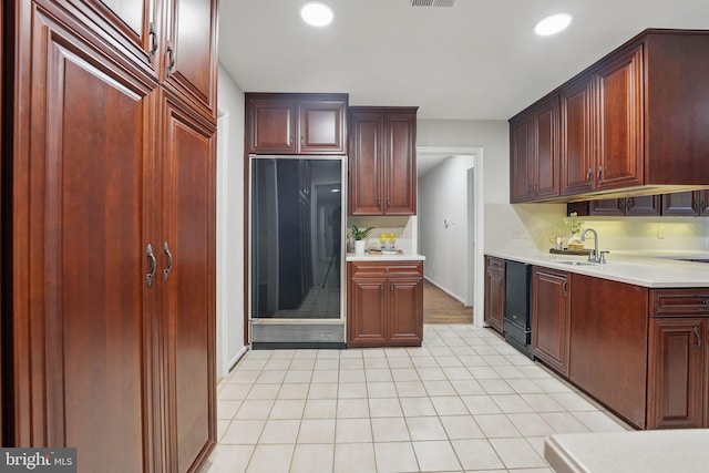 2624 Black Fir Ct, Reston, VA 20191 - kitchen with dark brown cabinets, light countertops, a sink, light tile patterned flooring, and recessed lighting
