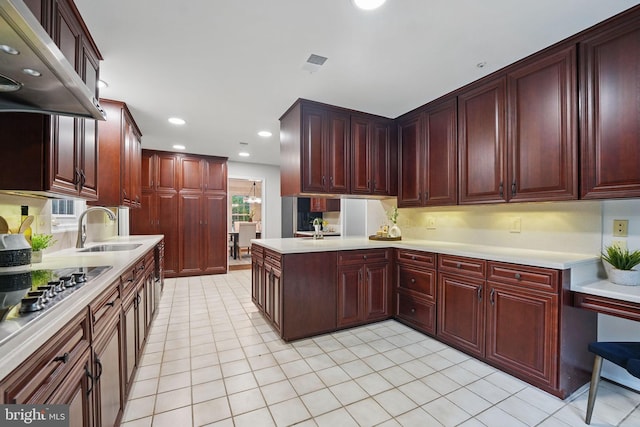 2624 Black Fir Ct, Reston, VA 20191 - kitchen featuring reddish brown cabinets, a sink, range hood, light countertops, and recessed lighting