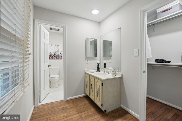2624 Black Fir Ct, Reston, VA 20191 - bathroom featuring toilet, wood-type flooring, double vanity, a spacious closet, and baseboards