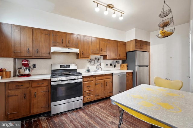 2347 E Norris St, Philadelphia, PA 19125 - kitchen with appliances with stainless steel finishes, under cabinet range hood, a sink, light countertops, and dark wood-style flooring