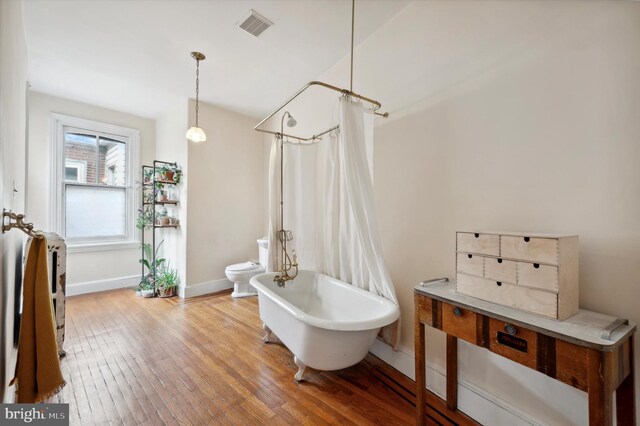 2347 E Norris St, Philadelphia, PA 19125 - bathroom with hardwood / wood-style floors, baseboards, toilet, and a combined bath / shower with freestanding tub