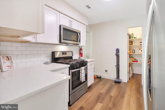 6 Carob Ct, Lumberton, NJ 08048 - kitchen with appliances with stainless steel finishes, white cabinets, light wood-style flooring, backsplash, and baseboards