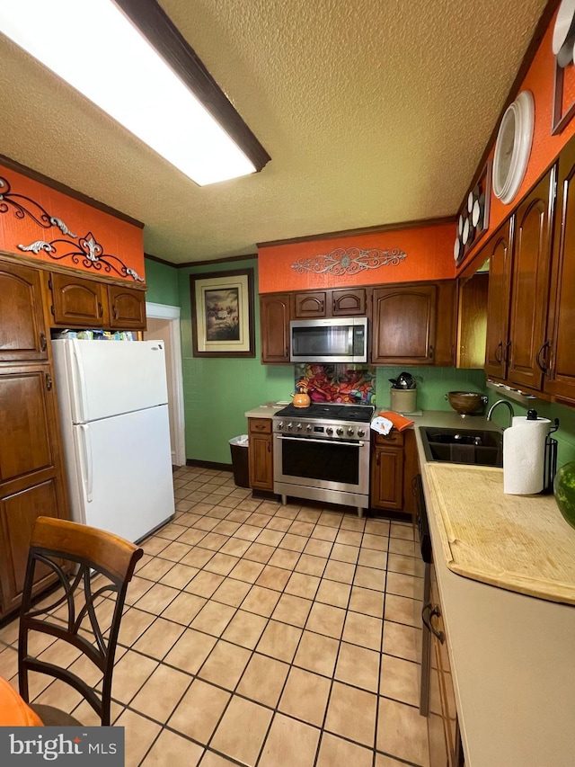 1116 N 19th St, Camden, NJ 08105 - kitchen with appliances with stainless steel finishes, a sink, light countertops, a textured ceiling, and light tile patterned floors