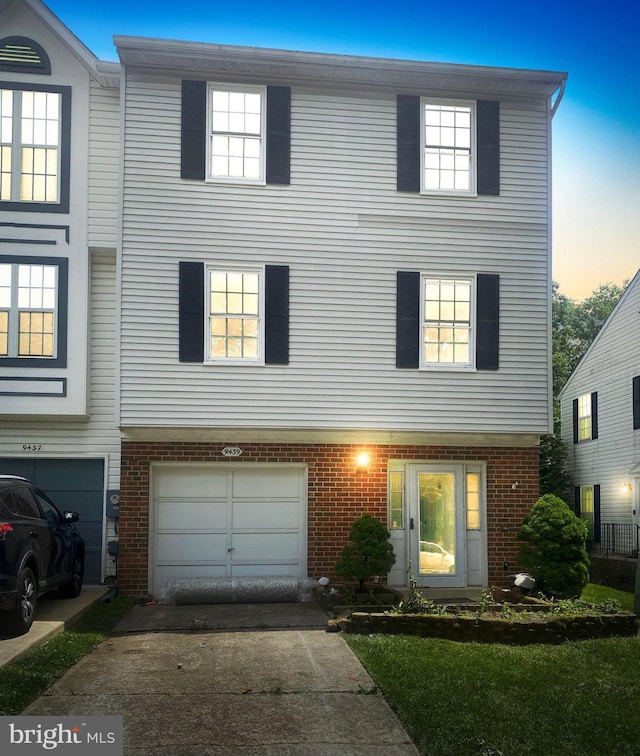 9439 Fens Holw, Laurel, MD 20723 - view of property featuring brick siding, driveway, and a garage