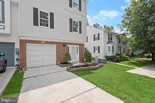 9439 Fens Holw, Laurel, MD 20723 - view of property with brick siding, a front lawn, an attached garage, and concrete driveway