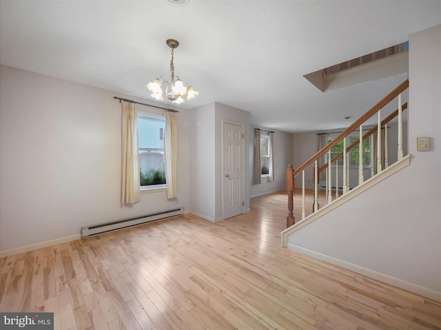 14754 Sherwood Dr, Greencastle, PA 17225 - empty room featuring baseboard heating, stairway, a chandelier, and healthy amount of natural light