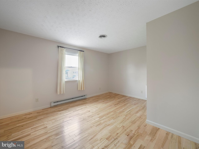 14754 Sherwood Dr, Greencastle, PA 17225 - spare room featuring baseboard heating, wood finished floors, baseboards, and a textured ceiling