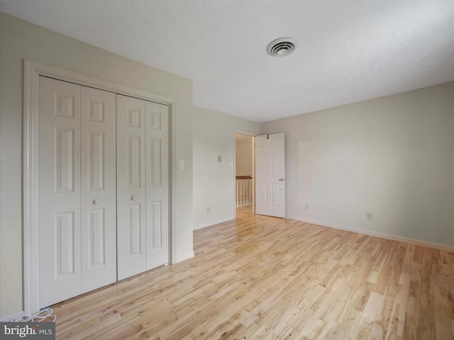 14754 Sherwood Dr, Greencastle, PA 17225 - unfurnished bedroom featuring light wood finished floors, a closet, baseboards, and a textured ceiling